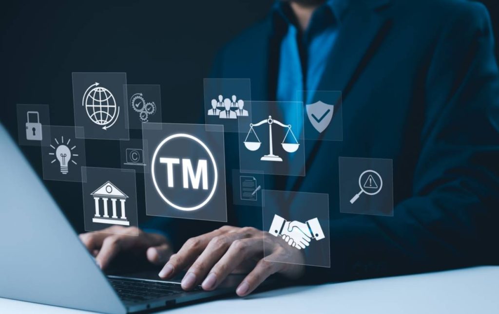 businessman using laptop trademark law protection icons TM symbol