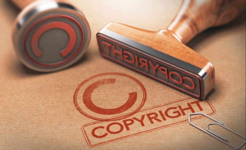 Red copyright symbol and text stamped on paper with wooden stamps.